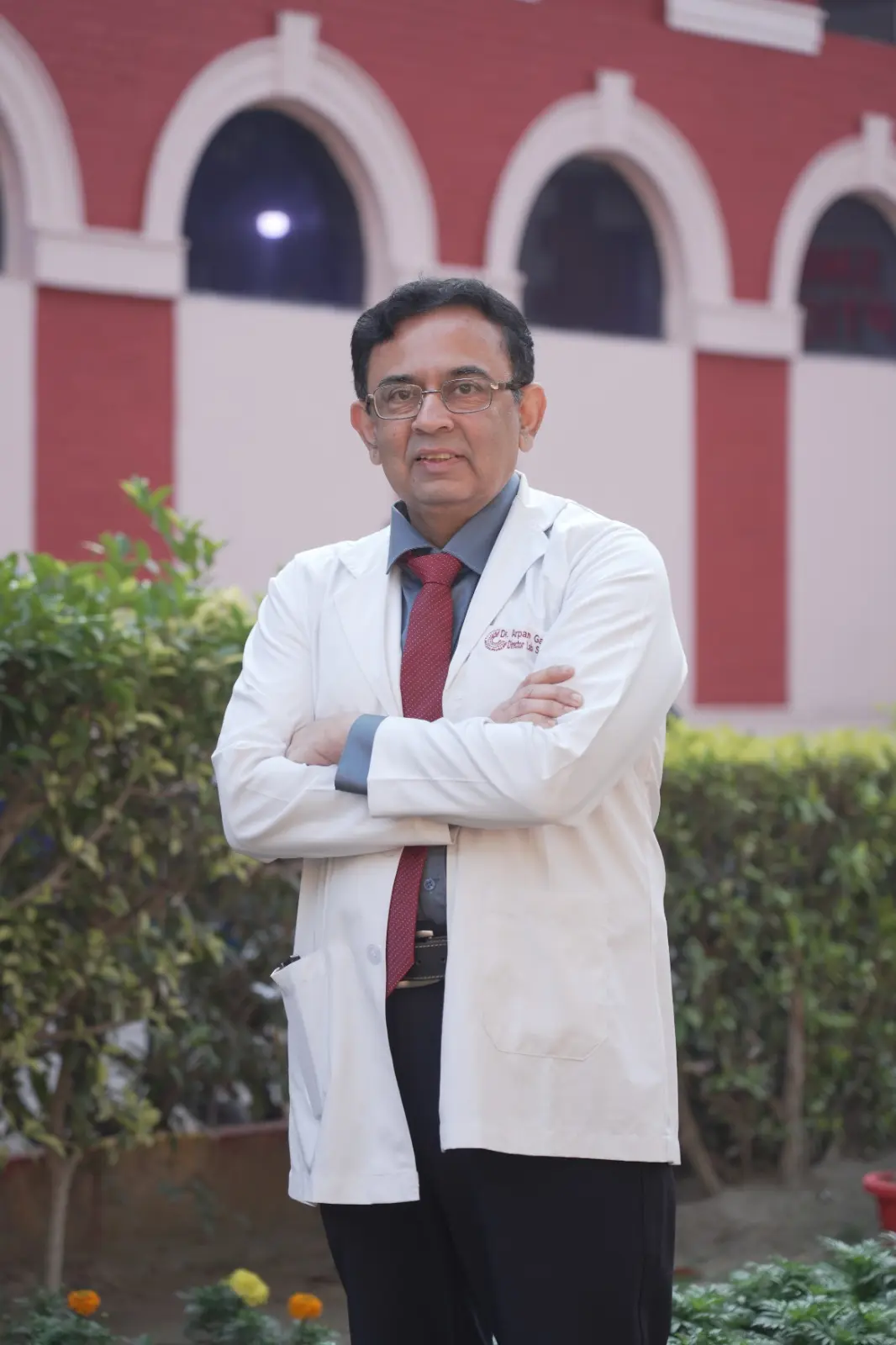 Dr. Arpan Gandhi in white coat at a heritage medical campus